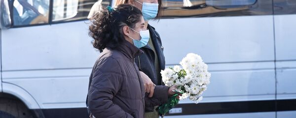 Эпидемия коронавируса. Жители столицы Грузии в масках идут с цветами по улице - Sputnik Грузия