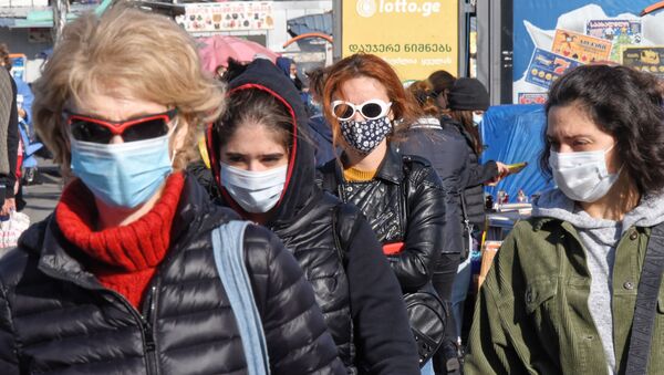 Эпидемия коронавируса. Жители столицы Грузии в масках и очках идут по улице - Sputnik Грузия
