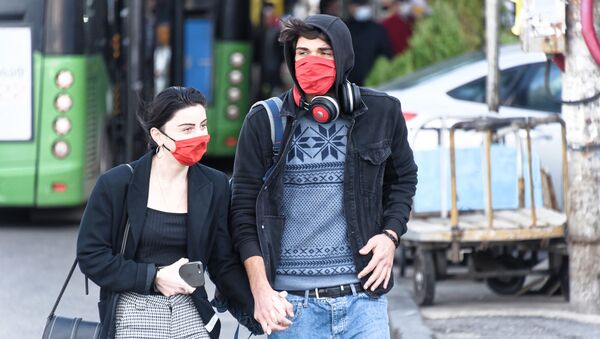 Эпидемия коронавируса. Молодые жители столицы Грузии в масках идут по улице - Sputnik Грузия