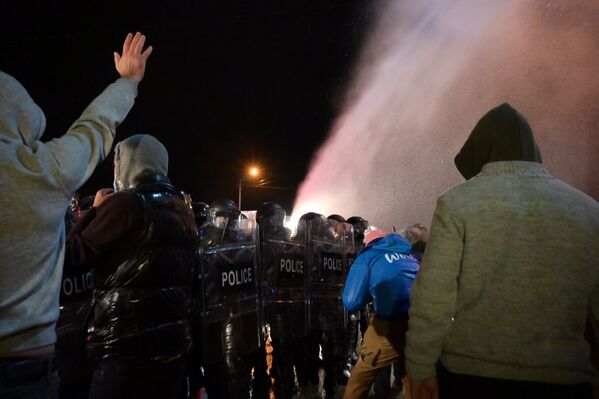 Группа протестующих кидала камни в полицейских, выстроившихся во дворе - Sputnik Грузия