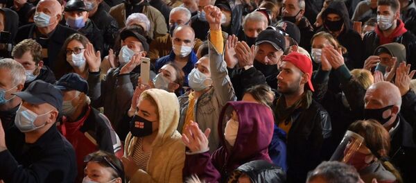 Поднятые руки. Люди в масках от коронавируса. Акция протеста оппозиции у здания парламента Грузии 9 ноября 2020 года - Sputnik Грузия