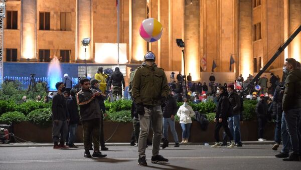 Парень в защитной маске играет с мячом на акции протеста у здания парламента Грузии 9 ноября 2020 - Sputnik Грузия