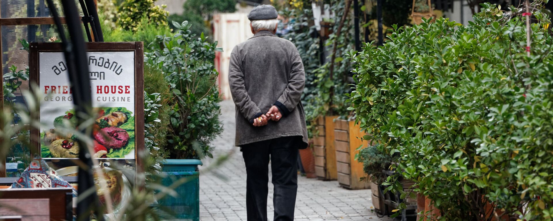 Пенсионер идет по улице мимо закрытых кафе и ресторанов - Sputnik Грузия, 1920, 11.02.2022