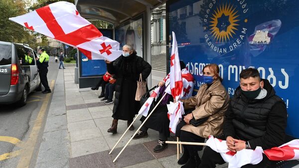Акция оппозиции 14 ноября 2020 года - пожилые женщины с флагами и в масках на автобусной остановке - Sputnik Грузия
