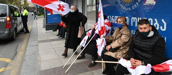 Акция оппозиции 14 ноября 2020 года - пожилые женщины с флагами и в масках на автобусной остановке - Sputnik Грузия