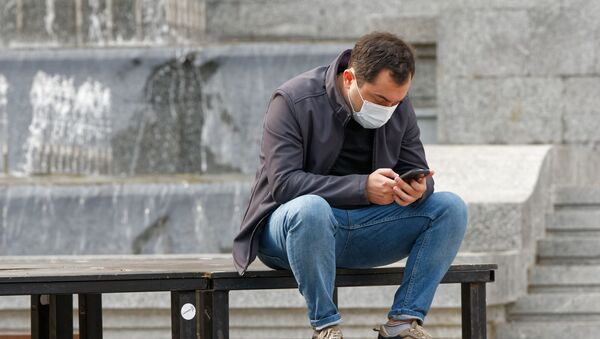 Эпидемия коронавируса - мужчина в маске на улице общается в соцсетях - Sputnik Грузия