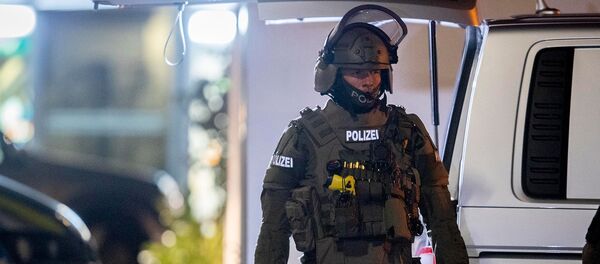 Офицер спецназа охраняет дорогу перед домом, который обыскивает полиция в Ханау после стрельбы в кальянной, где были убиты 8 человек (19 февраля 2020). Германия - Sputnik Грузия