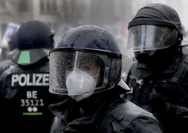 А вот полицейские, которых власти выводят на улицу для наведения порядка во время демонстраций, между тем, в масках и респираторах. На фото - сотрудники полицейского спецназа в Берлине, Германия - Sputnik Грузия