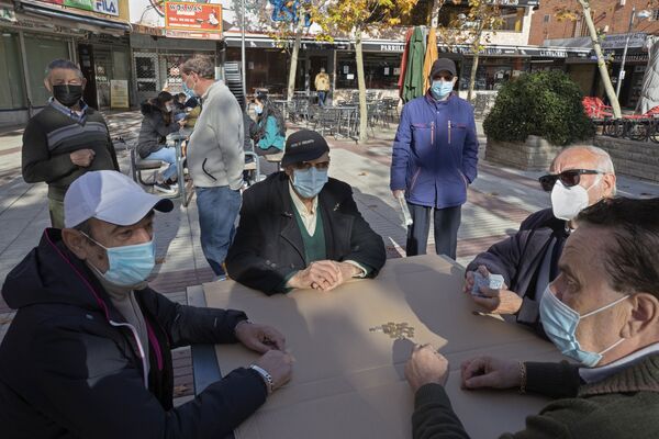 Пожилые жители Мадрида, Испания, играют в масках в карты под открытым небом во время пандемии коронавируса - Sputnik Грузия