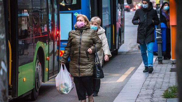 Эпидемия коронавируса - прохожие в масках на автобусной остановке - Sputnik Грузия
