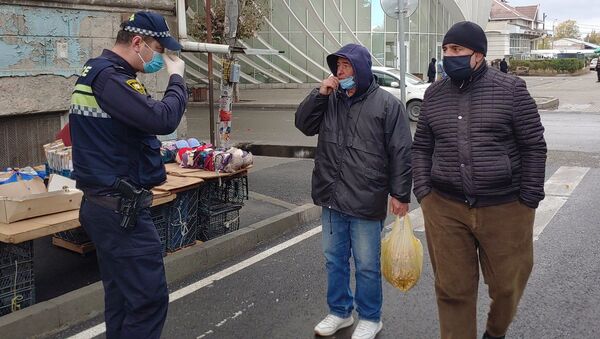 Эпидемия коронавируса - полицейские проверяют ношение масок прохожими на улице  - Sputnik Грузия