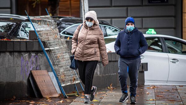 Эпидемия коронавируса - прохожие в масках на улицах грузинской столицы в дождь - Sputnik Грузия