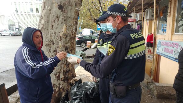 Эпидемия коронавируса - полиция проверяет ношение масок прохожими на улице  - Sputnik Грузия