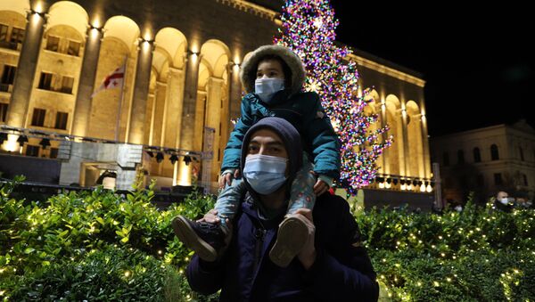 Прохожие в масках. Церемония зажжения огней на главной новогодней елке Грузии на проспекте Руставели - Sputnik Грузия