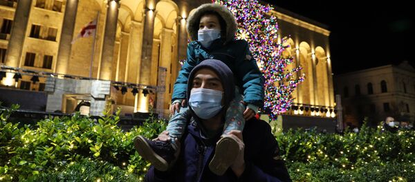 Прохожие в масках. Церемония зажжения огней на главной новогодней елке Грузии на проспекте Руставели - Sputnik Грузия