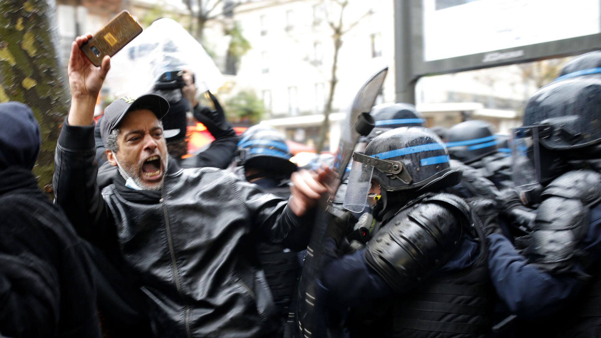 Участник протеста и полицейские в Париже  - Sputnik Грузия, 1920, 12.03.2023