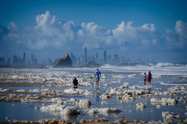 Туристы гуляют среди пены на пляже после циклона на пляже в Австралии - Sputnik Грузия
