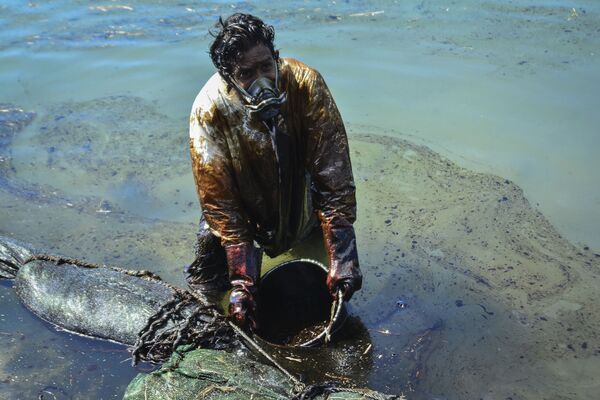მამაკაცი წყალს ასუფთავებს მავრიკიას ნაპირებზე დაღვრილი ნავთობისგან - Sputnik საქართველო