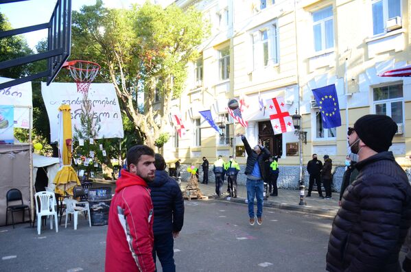 Недавно прямо на дороге напротив здания правительства Аджарии сторонники оппозиции установили баскетбольный щит. Теперь развлекаются, играя с мячом - Sputnik Грузия