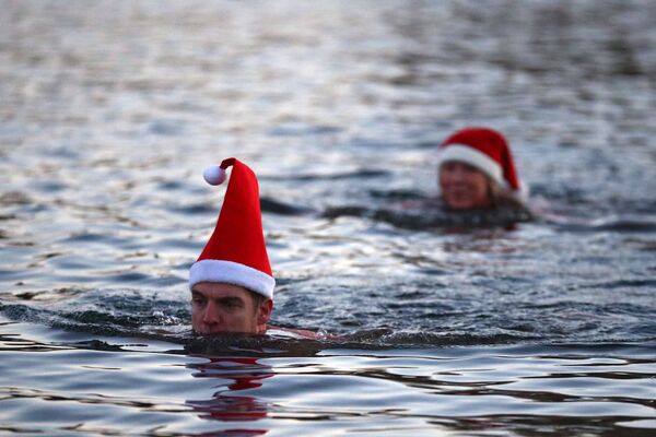 Люди в рождественских колпаках плавают в озере Серпентин в Гайд-парке в Лондоне - Sputnik Грузия