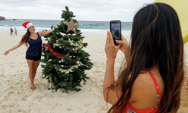 Девушки фотографируются у рождественской ели на пляже в Австралии - Sputnik Грузия