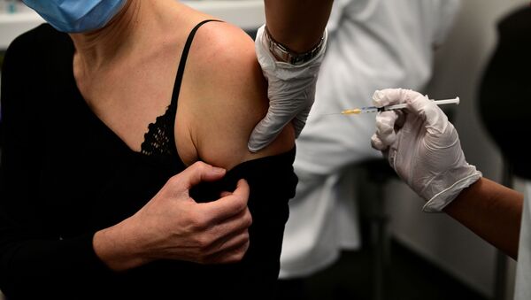 Женщина получает вакцину от COVID-19 - Sputnik Грузия