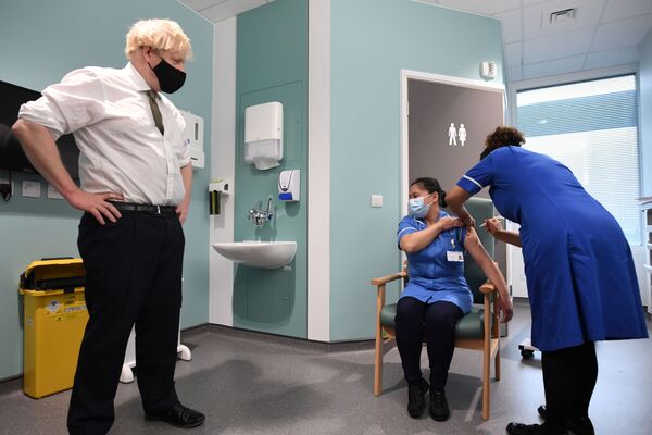 Премьер-министр Великобритании Борис Джонсон наблюдает за вакцинацией во время своего визита в больницу Chase Farm на севере Лондона - Sputnik Грузия