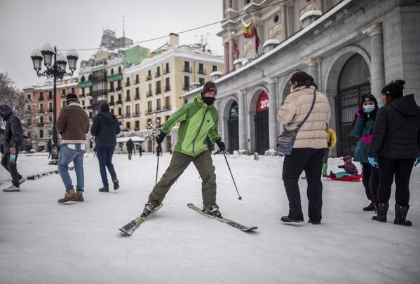 Мужчина едет на горных лыжах по одной из улиц в Мадриде - Sputnik Грузия