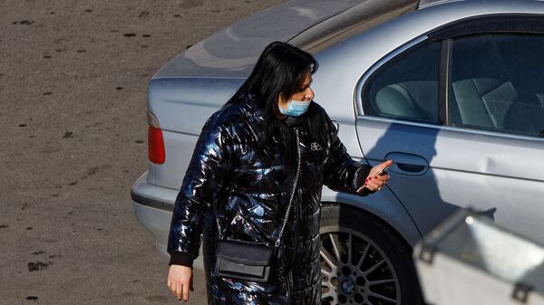 Эпидемия коронавируса - женщина в маске со смартфоном идет по улице - Sputnik Грузия