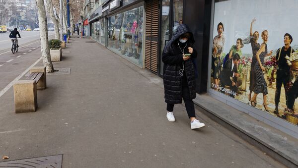 Эпидемия коронавируса - жительница столицы в маске идет мимо закрытых магазинов - Sputnik Грузия