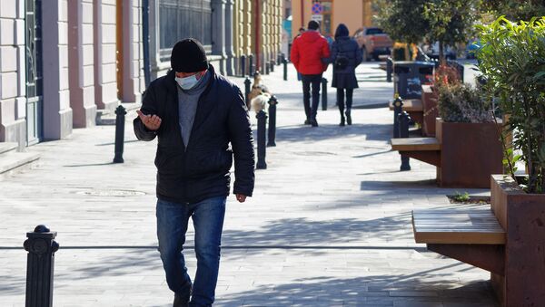 Эпидемия коронавируса - мужчина в маске зимой идет по улице - Sputnik Грузия