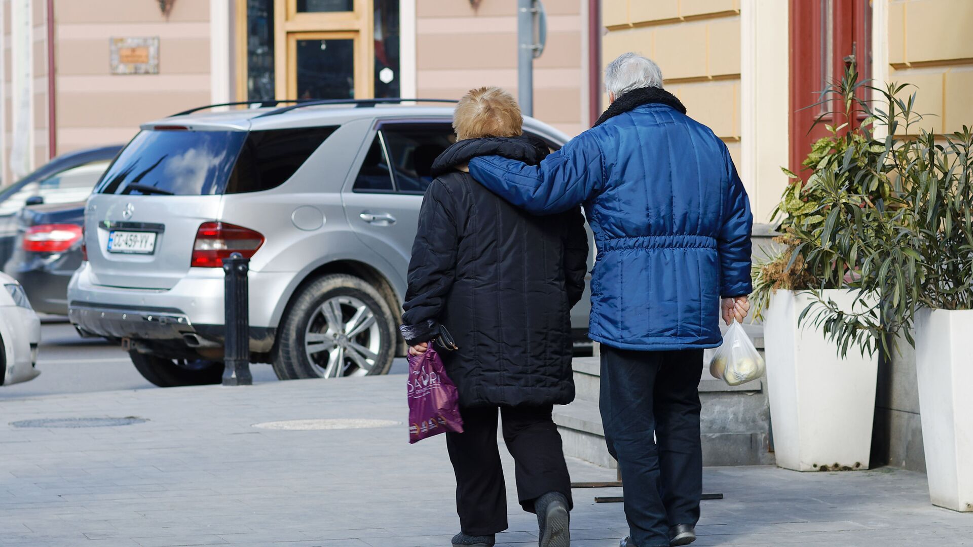 Пожилая семейная пара идет по улице с покупками - Sputnik Грузия, 1920, 06.03.2022
