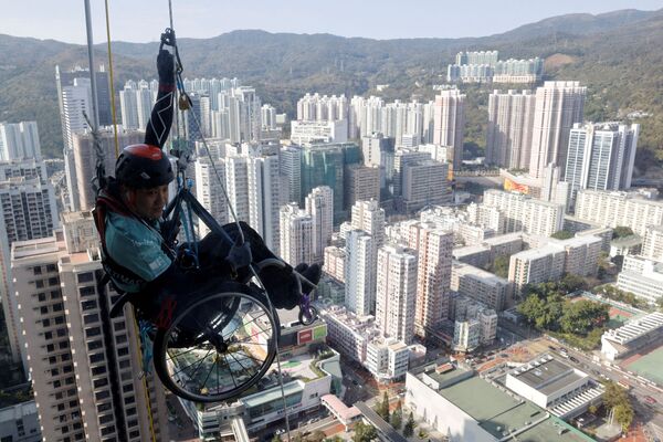 Альпинист Lai Chi-wai с параличом нижних конечностей пытается подняться на башню Nina в Гонконге - Sputnik Грузия