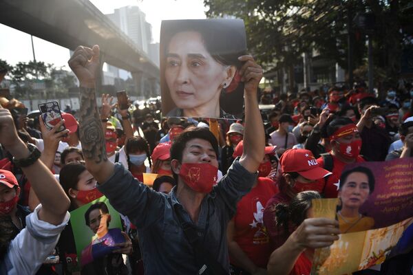 Так же, как и мигранты в Таиланде, они держат портреты Аунг Сан Су Чжи во время демонстрации - Sputnik Грузия
