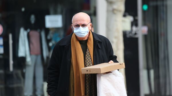 Эпидемия коронавируса - пожилой мужчина в маске и очках идет с покупками по торговому центру - Sputnik Грузия