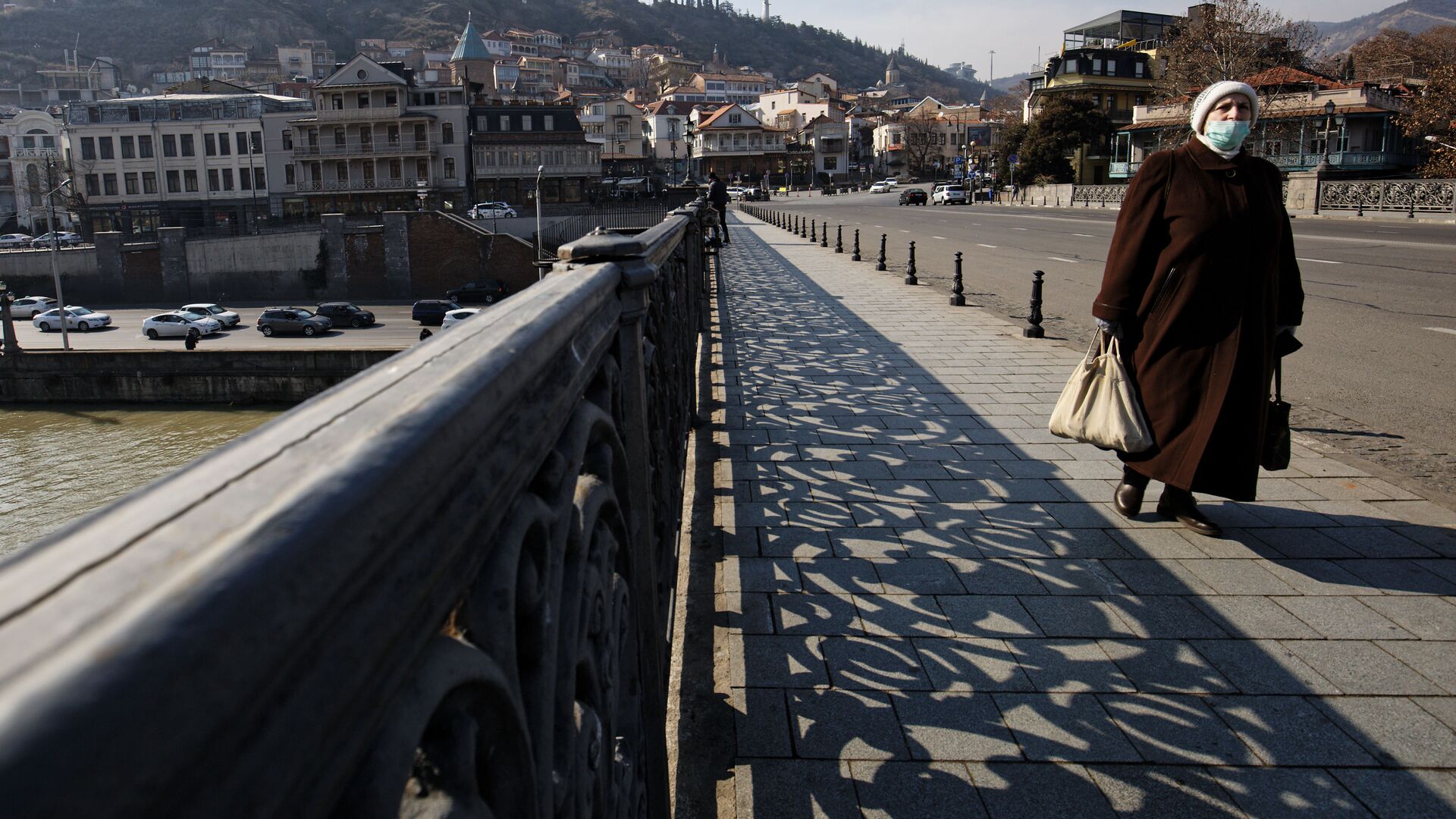Вид на город Тбилиси - пожилая женщина в маске идет по Метехскому мосту - Sputnik Грузия, 1920, 11.12.2021