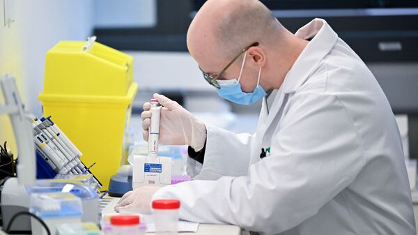 Медик в лаборатории использует пипетку для обработки образцов для тестирования на новый штамм коронавируса - Sputnik Грузия