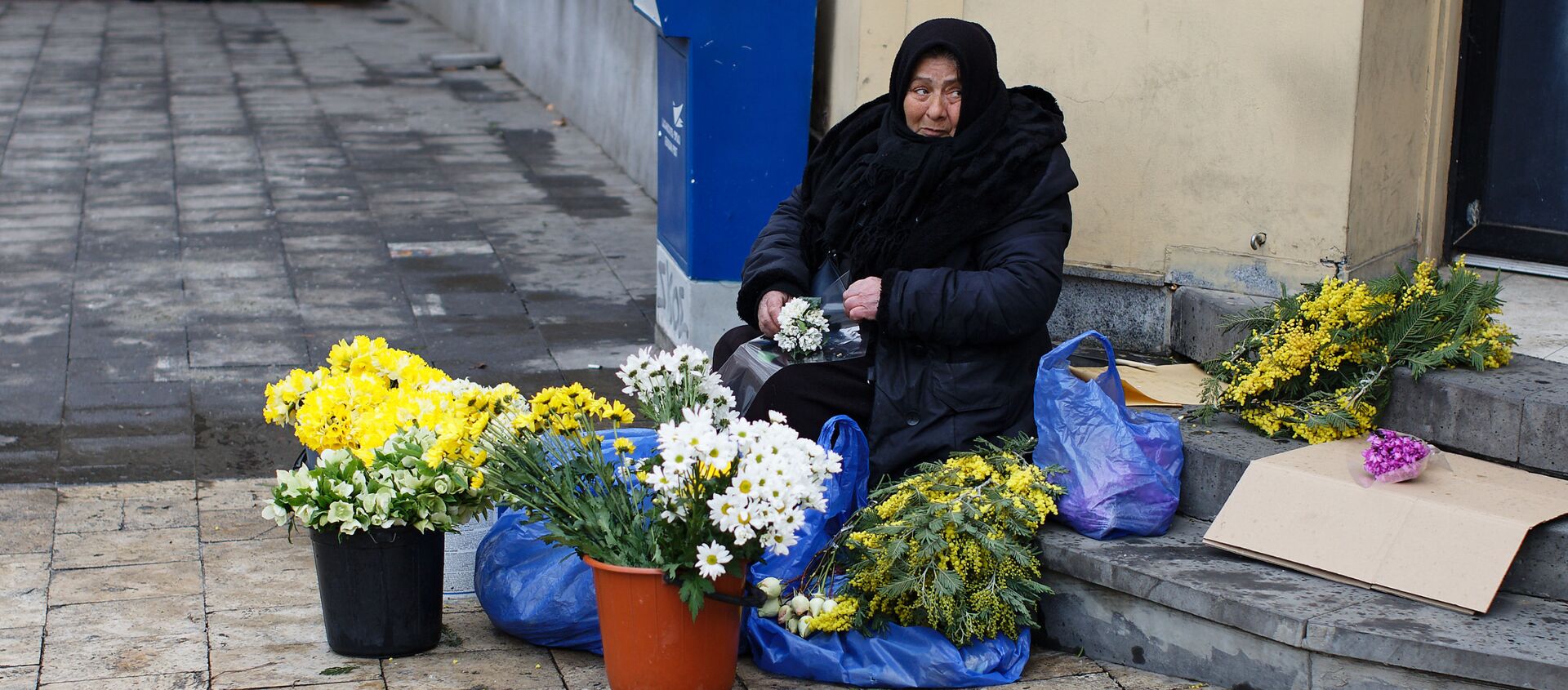 Пожилая продавщица цветов на улице торгует и зимой - Sputnik Грузия, 1920, 11.04.2021
