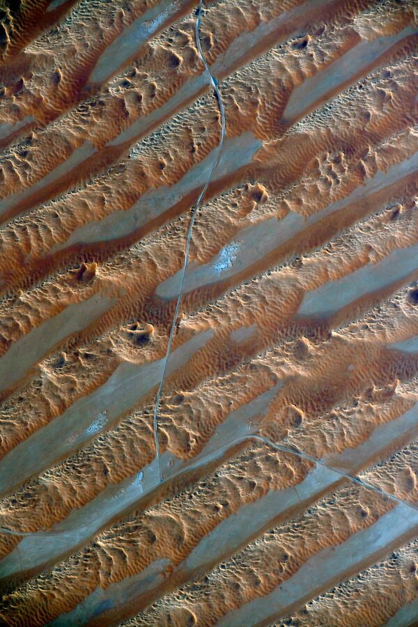 Движущиеся барханы Аравийской пустыни, снятые российским космонавтом Сергеем Кудь-Сверчковым. Большая часть территории необитаема из-за частых песчаных и пыльных бурь, сильных ветров и высоких температур с обычными для пустынь большими суточными амплитудами - Sputnik Грузия
