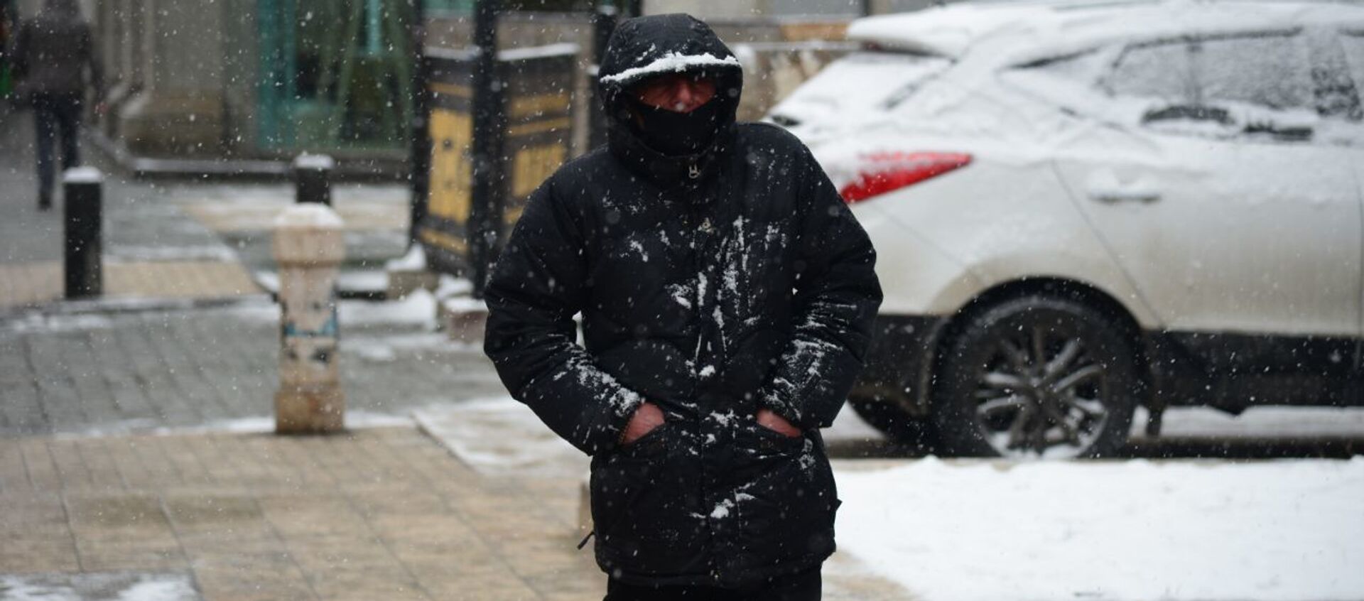 Эпидемия коронавируса - прохожий на улице в маске в снег - Sputnik Грузия, 1920, 24.02.2021