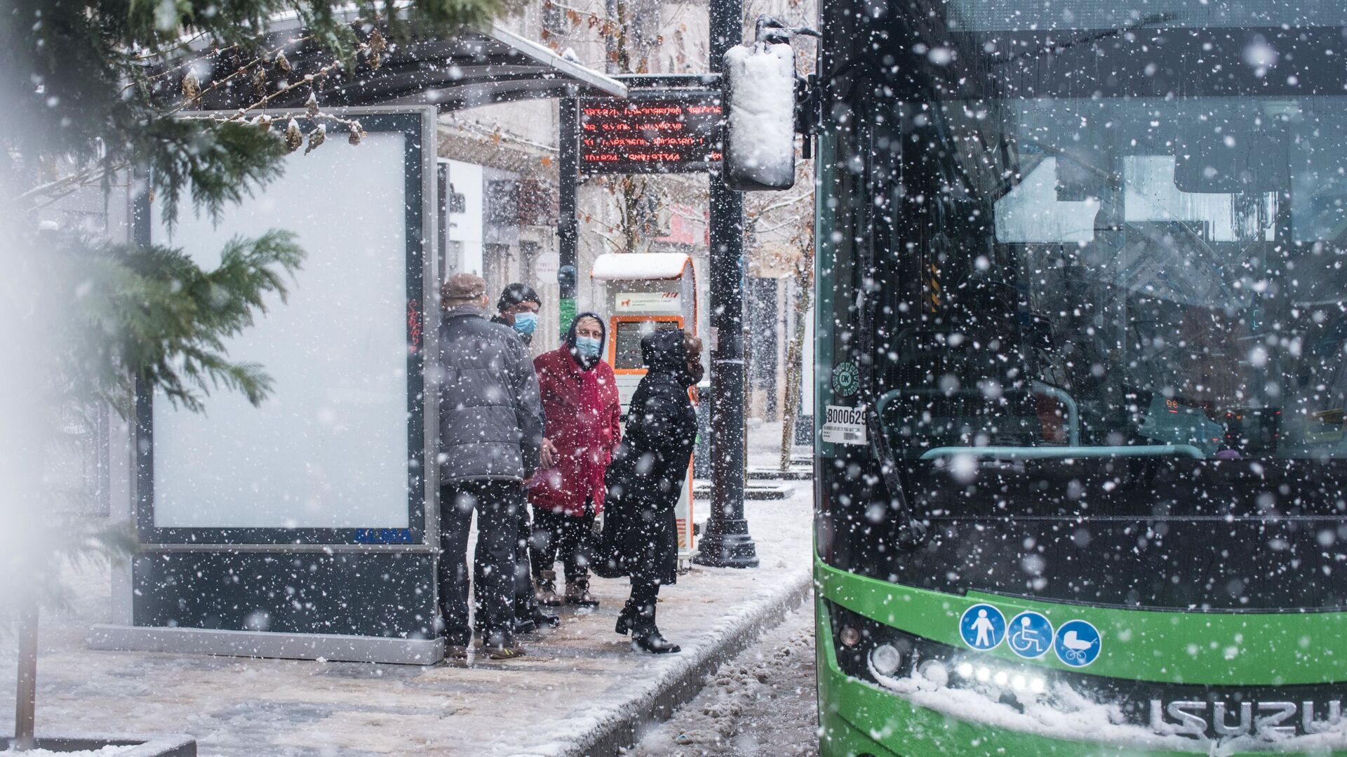 Эпидемия коронавируса - пассажиры в масках на автобусной остановке в снег - Sputnik Грузия, 1920, 21.03.2022