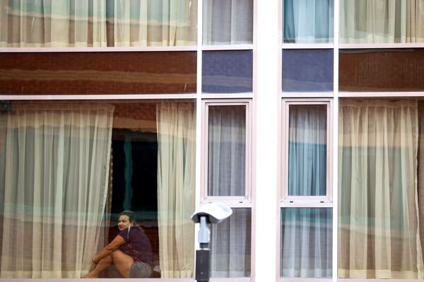 Женщина смотрит из окна отеля Radisson Blu в аэропорту Хитроу - Sputnik Грузия