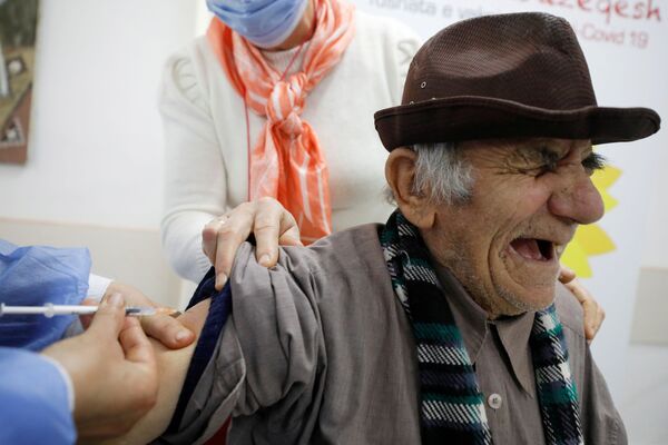 Пожилой мужчина во время вакцинации в Фиери - Sputnik Грузия