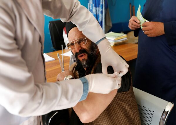 Работник больницы во время вакцинации AstraZeneca в Кабуле - Sputnik Грузия