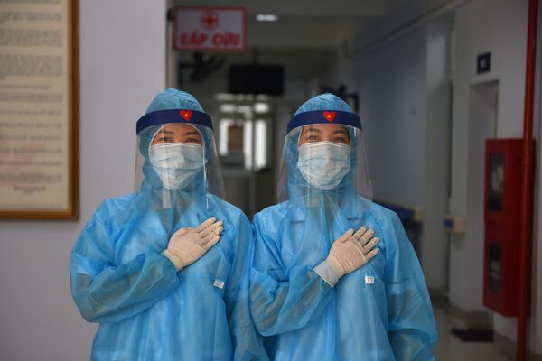 Медицинские работники в защитной одежде во временном центре тестирования коронавируса во Вьетнаме - Sputnik Грузия
