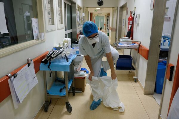 Медсестра перед посещением палаты с больными коронавирусом пациентами в больнице в Лиссабоне - Sputnik Грузия