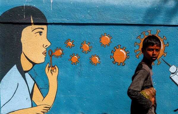 Мальчик проходит мимо граффити в Мумбаи - Sputnik Грузия