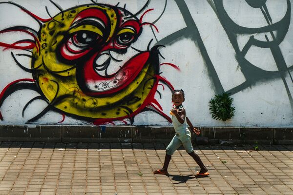 Ребенок у граффити с изображением COVID-19 в Совето, ЮАР - Sputnik Грузия