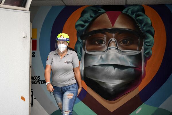 Медицинский работник в защитной маске у граффити в Каракасе - Sputnik Грузия