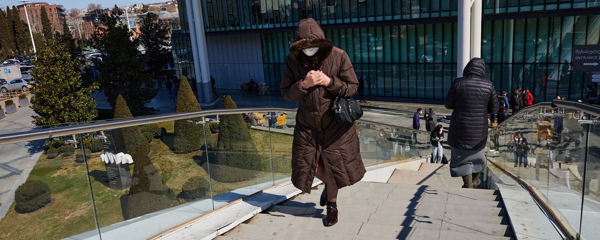 Эпидемия коронавируса - женщина в маске идет по мосту у Дома Юстиции - Sputnik Грузия, 1920, 05.12.2021